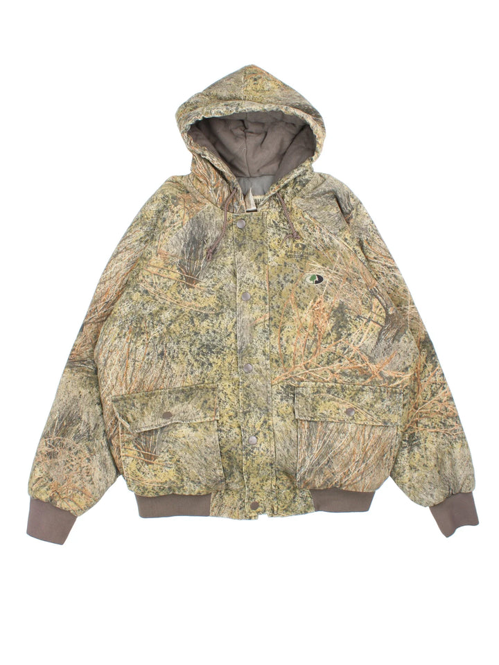 Vintage Russell Athletic Outdoors Mossy Oak Hooded Jacket in a green and green colourway. Zips up and has multiple pockets, insulated with a quilted lining, and has the logo embroidered on the front.