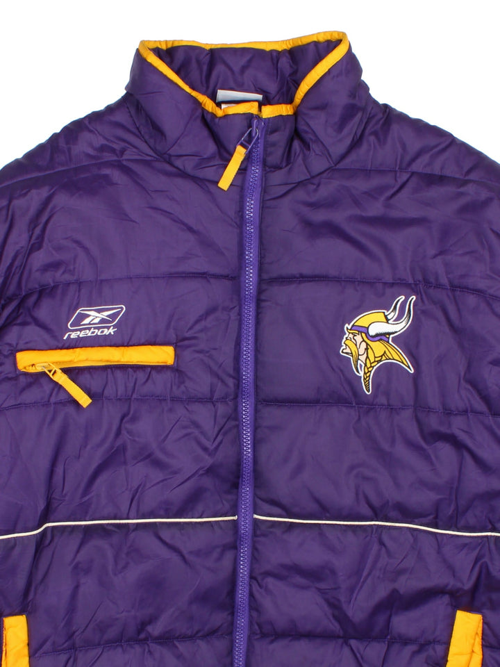 Vintage Minnesota Vikings Reebok NFL Puffer Jacket in a purple and yellow colourway. Zips up and has multiple pockets, insulated lining, and has the logos embroidered on the front.