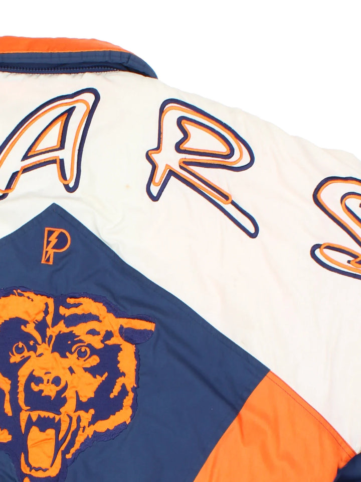 90's Chicago Bears Pro Player Jacket in a white and blue colourway with orange detailing. Full zip up and two pockets on the front with large team logo on the front and sleeves with larger logo and graphic across the back.