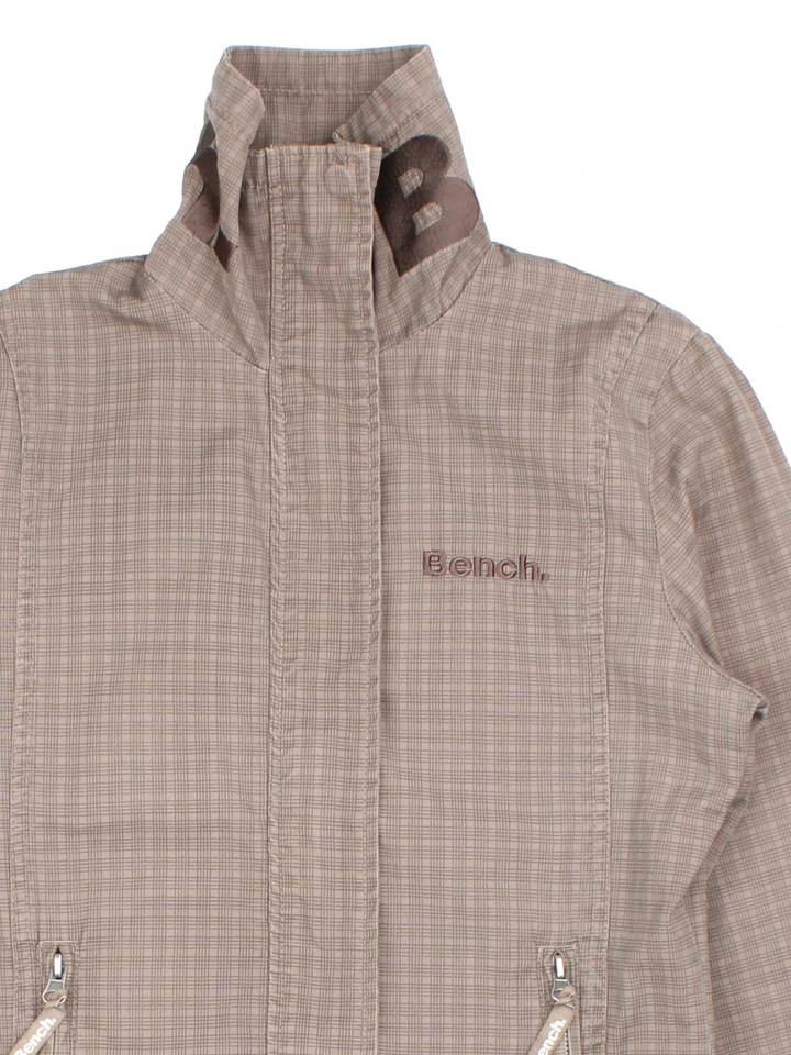 Y2K Bench Jacket in a brown colourway. Zip fastening with side zip pockets and embroidered branding on front/collar.