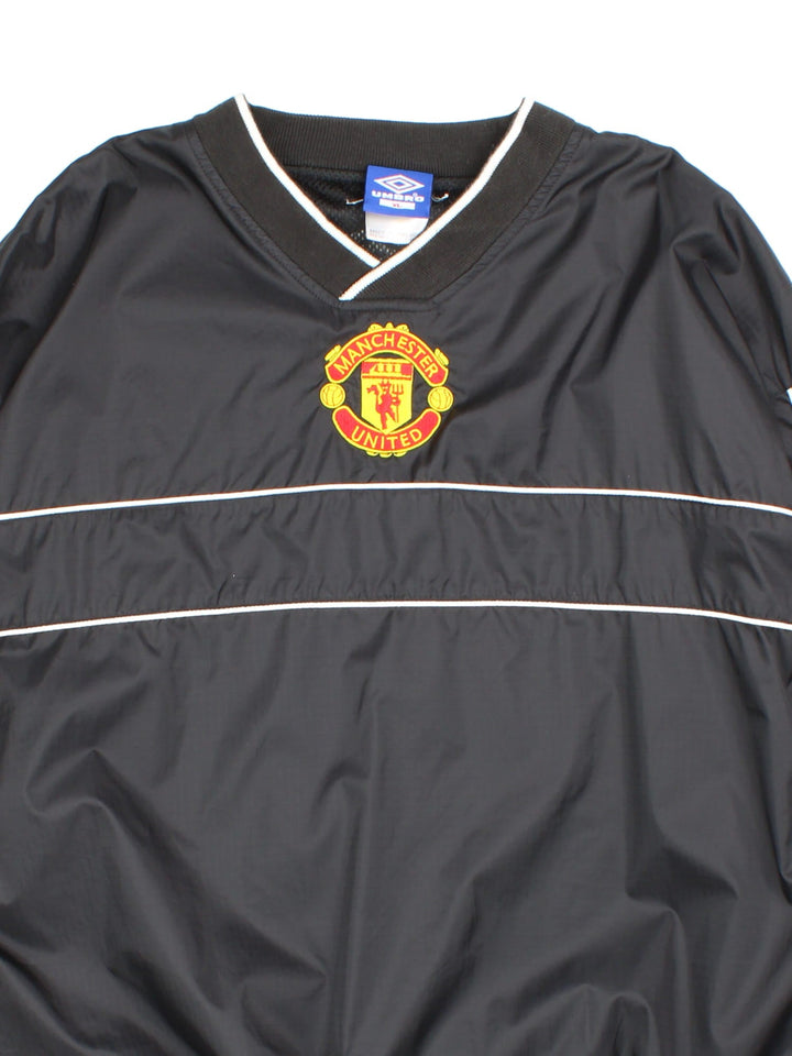 Vintage 90's Manchester United Umbro Drill Training Top in a black colourway. V neck collar and has side pockets, mesh lining, and has the logos embroidered on the front and back.