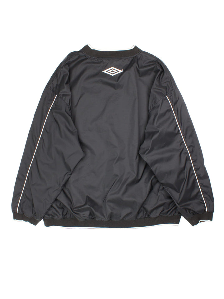 Vintage 90's Manchester United Umbro Drill Training Top in a black colourway. V neck collar and has side pockets, mesh lining, and has the logos embroidered on the front and back.