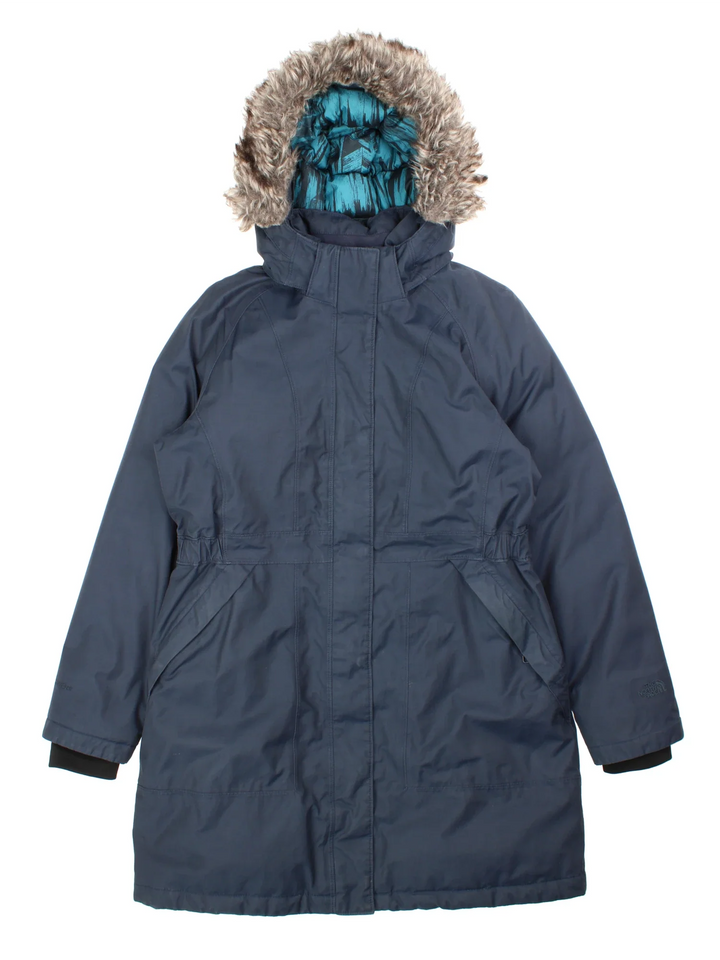 The North Face Parka Coat in a blue colourway with faux fur hood. Full zip with buttons nd two pockets on the side. Small classic logo on the back.