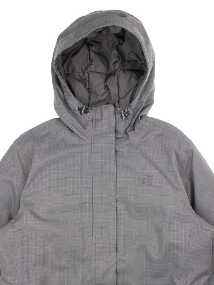 The North Face Hyvent Jacket in a grey colourway. Goose down lining full zip and buckle waist. Multiple pockets on the front and drawstring hood with small classic logo on the chest and buckle.