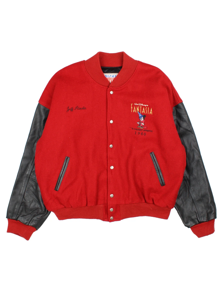 1940 Fantasia Disney Studios Bomber Jacket in a red colourway with black leather panelling on the sleeves. Buttons up and has side pockets, insulated with a quilted lining, and has the logos embroidered on the front, with large graphic on the back.