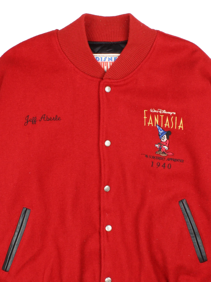 1940 Fantasia Disney Studios Bomber Jacket in a red colourway with black leather panelling on the sleeves. Buttons up and has side pockets, insulated with a quilted lining, and has the logos embroidered on the front, with large graphic on the back.
