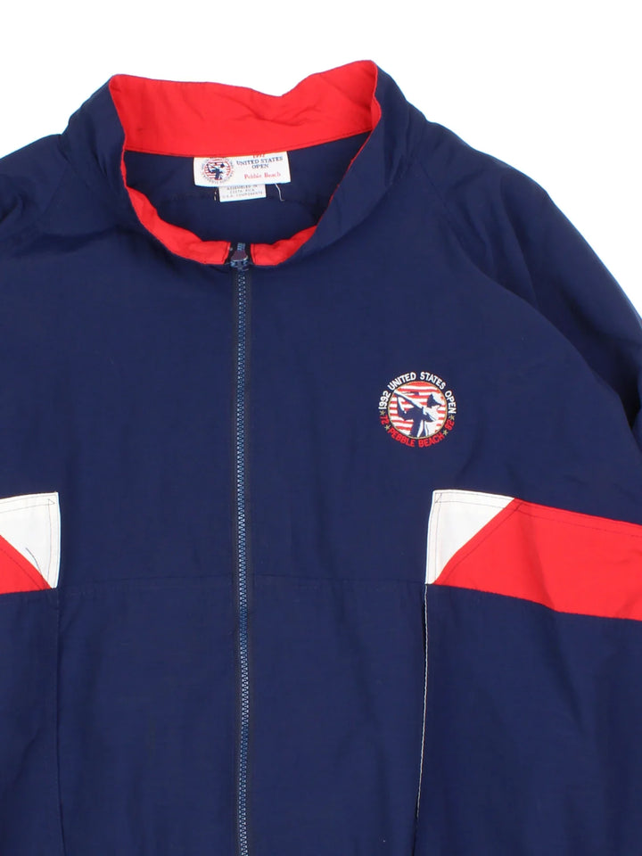 Vintage 1992 US Open Pebble Beach Jacket in a blue colourway with red and white panelling. Full zip with two pockets and small logos on the front and sleeve. Logo and detailing running across the back. 