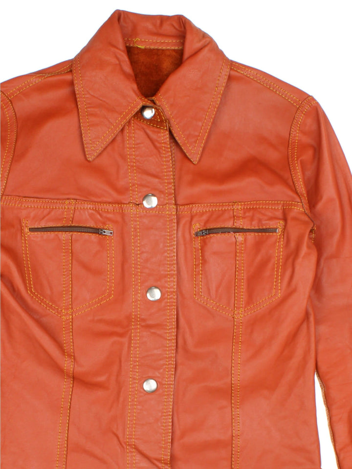 Vintage 80's Reversible Leather Jacket in a orange colourway in either a leather or suede reversible options. Buttons up and has double chest pockets, and features contrast stitching details.