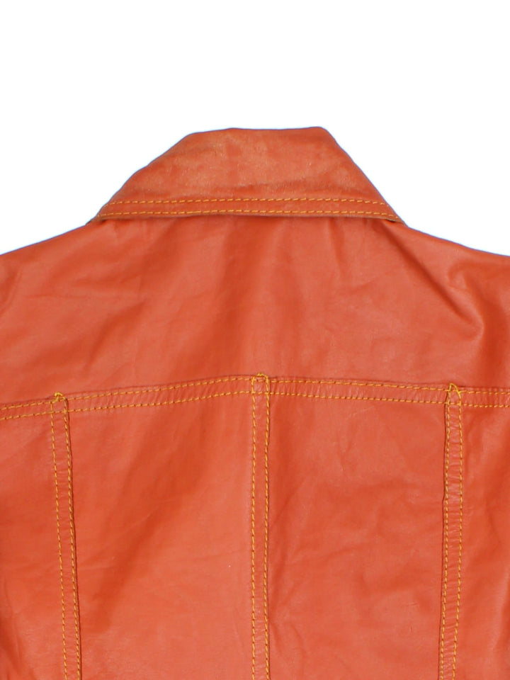 Vintage 80's Reversible Leather Jacket in a orange colourway in either a leather or suede reversible options. Buttons up and has double chest pockets, and features contrast stitching details.