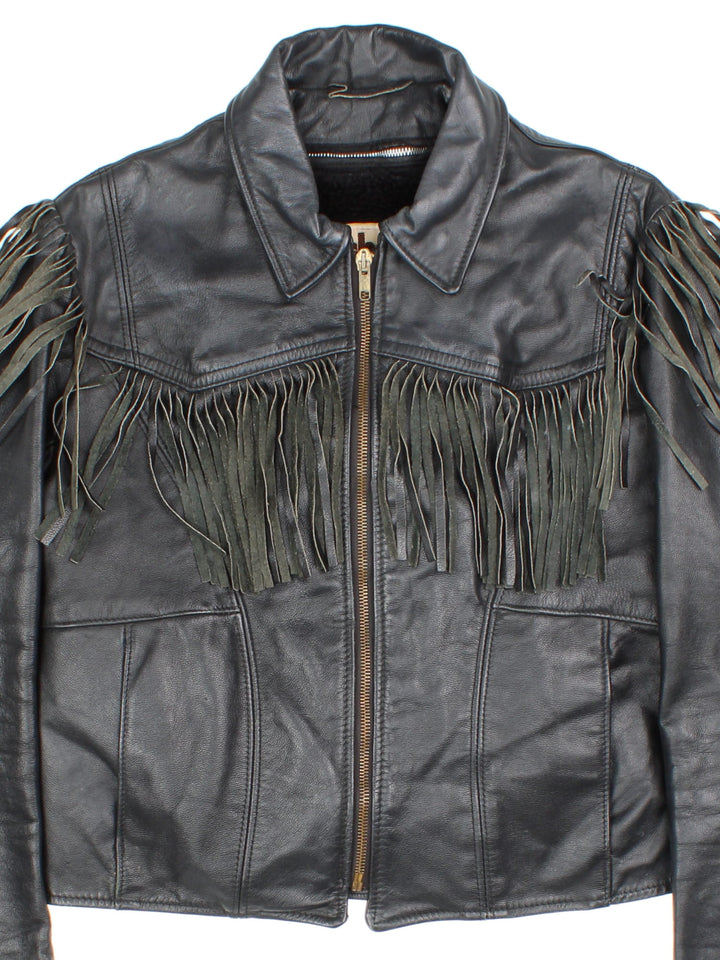 Vintage Schott Leather Fringe Jacket in a black colourway. Zips up and has side pockets, insulated with a detachable sherpa lining, and has fringe tassel details on the front, back and down the sleeves.
