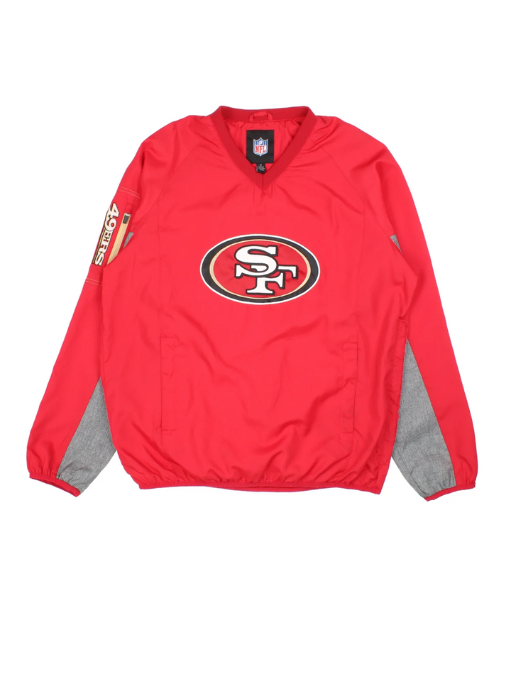 NFL San Francisco 49ers Training Top in a red/grey colourway. Pullover with side pockets, contrast cuffs and hem. Logos embroidered on front and sleeve.