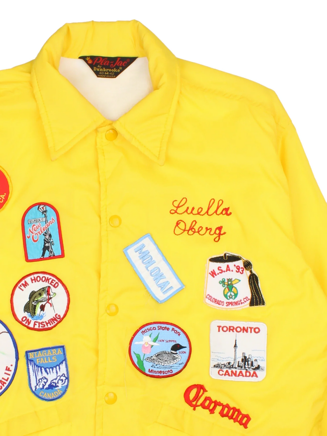 70's Vintage Coach Jacket in a yellow/multi colourway. Button popper fastening with front pockets, elasticated cuffs and hem with brushed lining. Embroidered patches and logos on front and back.