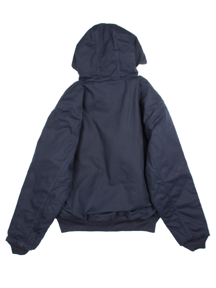 Carhartt Active Jacket in a navy blue colourway. Zips up and has side pockets, insulated with a quilted lining, hooded, and has the Carhartt amd 'Colins Framing' company logo embroidered on the front.