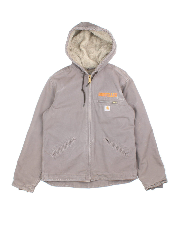 Carhartt Jacket in a grey colourway. Zips up and has multiple pockets, insulated with a sherpa lining, and has the logo and 'Goodfellow' logo embroidered on the front.