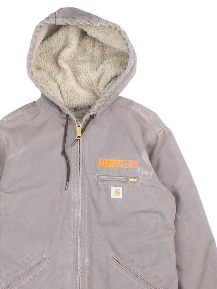 Carhartt Jacket in a grey colourway. Zips up and has multiple pockets, insulated with a sherpa lining, and has the logo and 'Goodfellow' logo embroidered on the front.