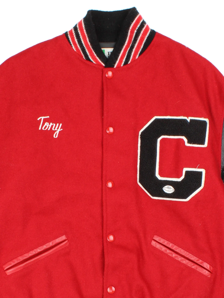 Vintage 80's Varsity Jacket in a red/black colourway. Buttons up, with contrast leather sleeves, elasticated hems/cuffs with embroidered detailing.