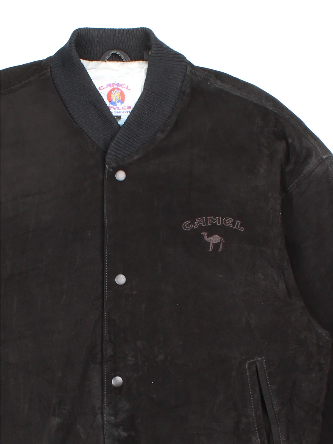 Vintage 90's Camel Suede Bomber Jacket in a black colourway. Buttons up and has side pockets, insulated with a satin lining, and has the logo embroidered on the front.