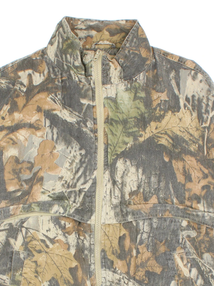 Real Tree Camo Bomber Jacket  in a green colourway. Zip fastening, side pockets, quilted lining and back patch detail.