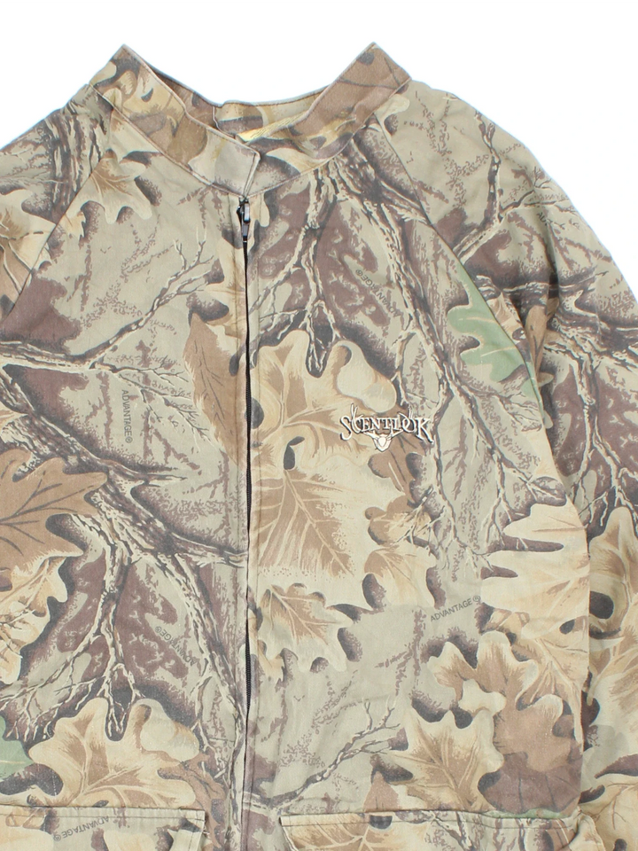 Real Tree Camo Military Jacket  in a green colourway. Zip fastening, front pockets, mesh lining and embroidered branding on the front.