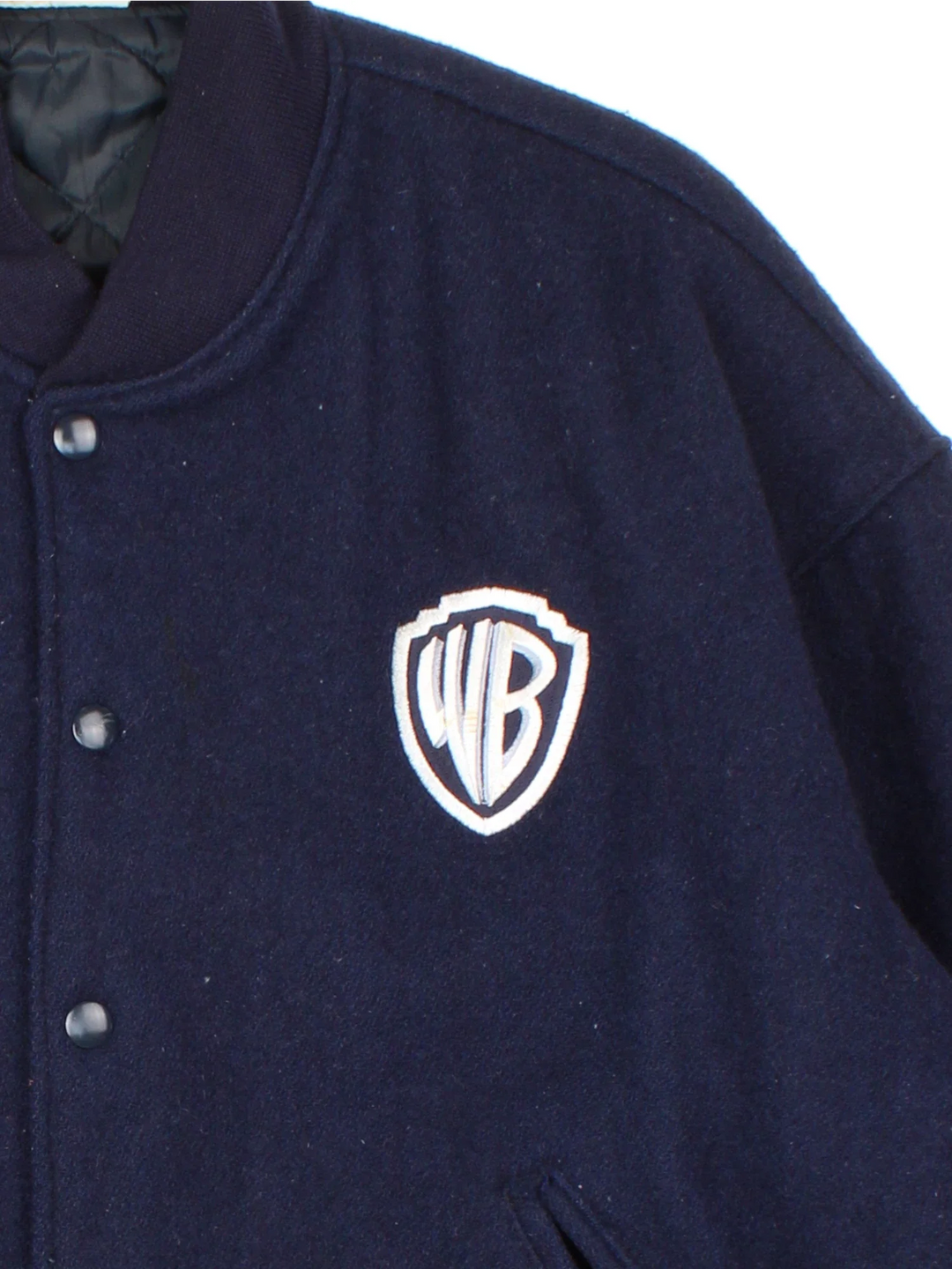 1998 Warner Bros Looney Tunes Woollen Varsity Jacket in a navy blue colourway. Buttons up and has side pockets, insulated with a quilted lining, and has the logo embroidered on the front and characters / spell out on the back.
