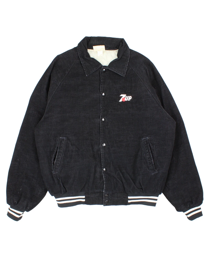 Vintage 1980's 7up Corduroy Jacket in a black colourway. Buttons up and has side pockets, insulated with a quilted lining, and has the logo embroidered on the front.