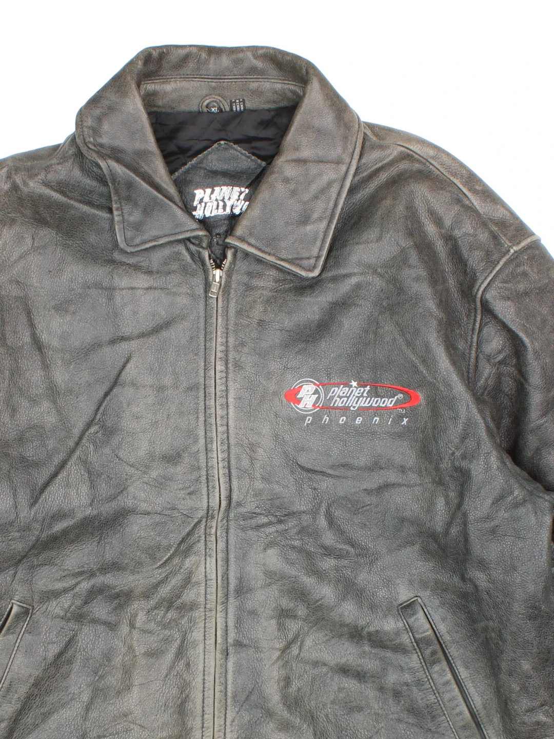 Vintage 90's Planet Hollywood Leather Jacket in a grey colourway. Zips up and has side pockets, insulated with a quilted lining, and has the logo embroidered on the front.