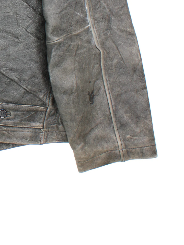 Vintage 90's Planet Hollywood Leather Jacket in a grey colourway. Zips up and has side pockets, insulated with a quilted lining, and has the logo embroidered on the front.