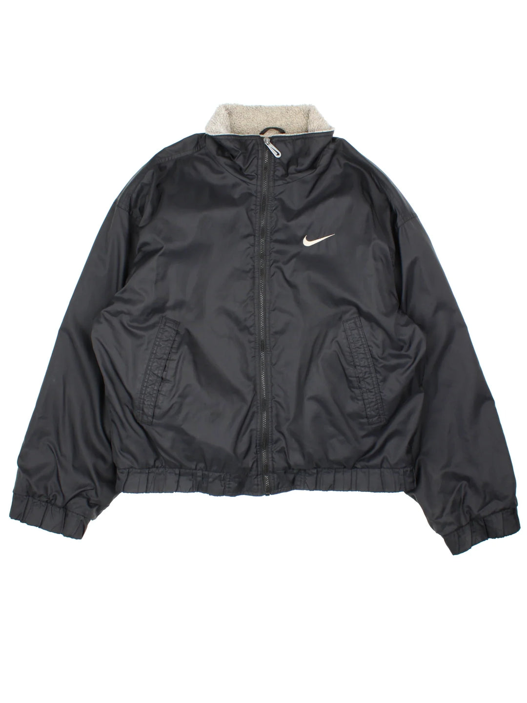 90's Nike Bomber Jacket in a black colourway. Zips up and has side pockets, insulated with a fleece lining, and has the swoosh logo embroidered on the front.