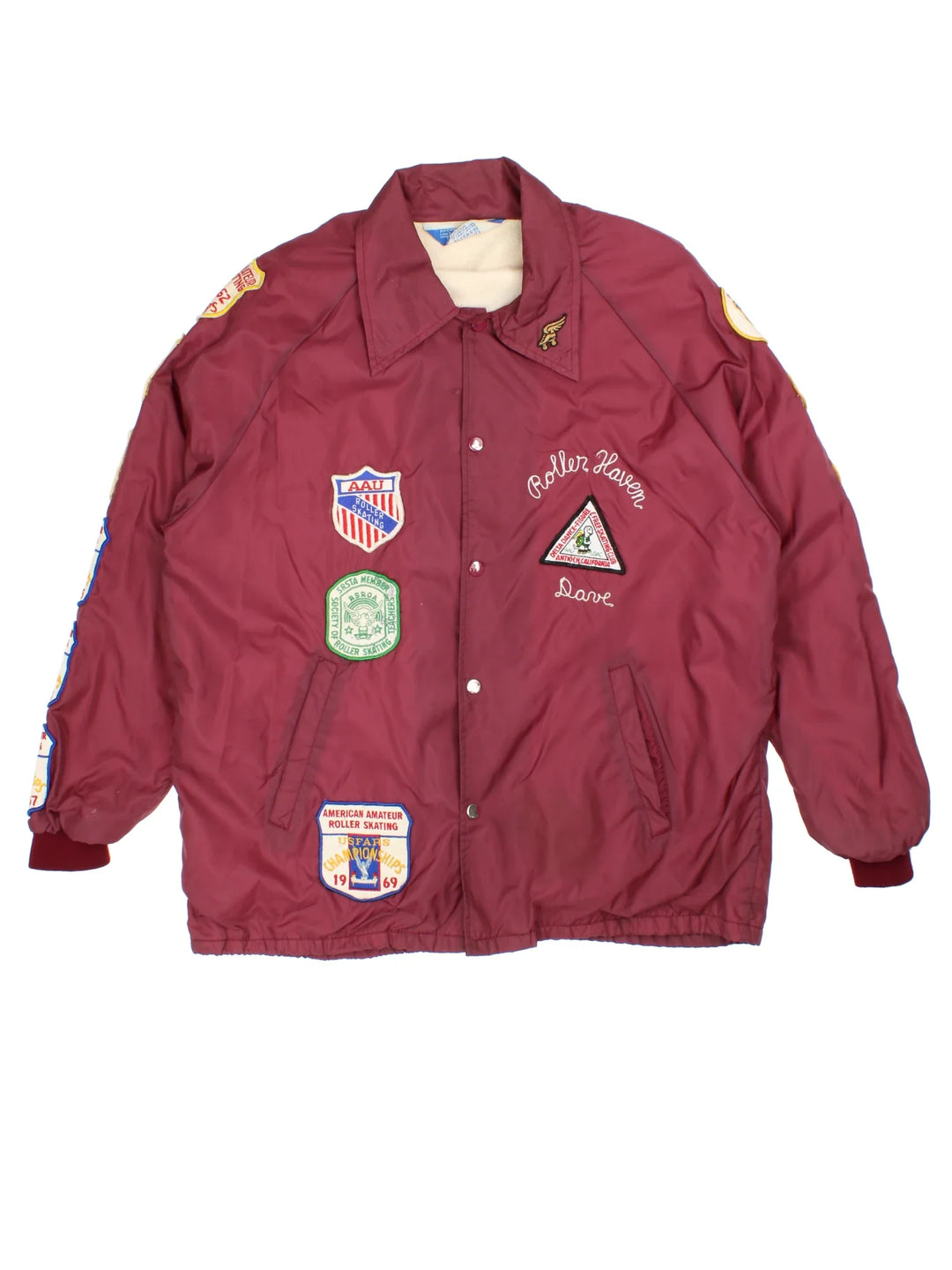 Vintage 1960's Roller Skating Champion Patch Coach Jacket in a red colourway. Buttons up and has side pockets, and patchwork badges embroidered on the front and sleeves.