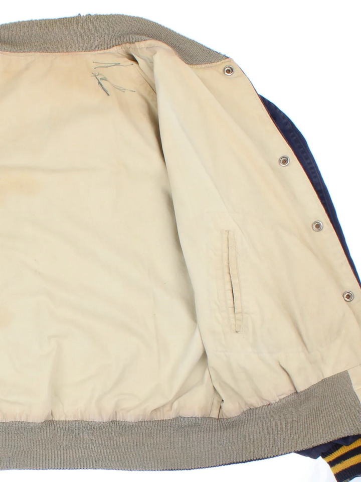 Vintage 1960's Notre Dame Varsity Jacket in a blue and yellow colourway. Buttons up and has side pockets, and has the spell out embroidered on the back.