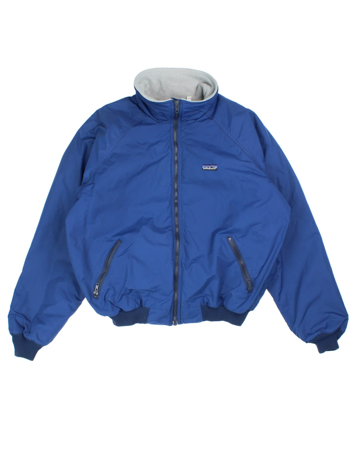 Vintage 90's Patagonia Fleece Lined Bomber Jacket in a blue colourway. Zip fastening, with side pockets, fleece lining and has the logo embroidered on the front.
