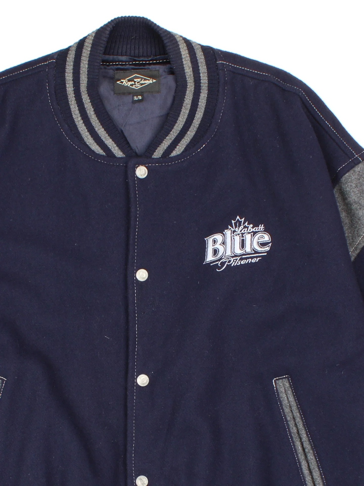 Vintage 90's Roger Edwards Sports Varsity Jacket in a blue colourway. Zip up closure, has side pockets, woollen with a insulated lining, and has the logos embroidered on the front and sleeves.