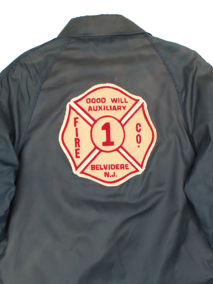Vintage 1980's Fire Fighter Coach Jacket in a navy blue colourway. Zips up and has side pockets, detachable insulated fleece lining, and the logo embroidered on the back.