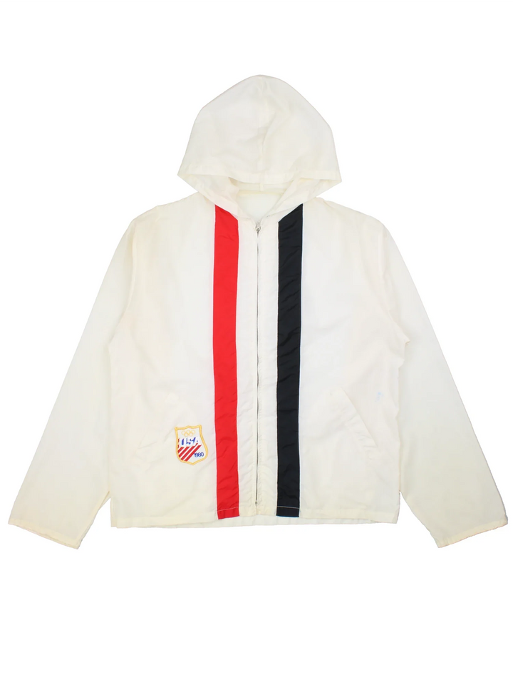 Vintage 1980 USA Team Olympics Nylon Jacket Jacket in a white colourway with a red and black stripe going down the front. Zips up and has side pockets, hooded and the USA Team logo embroidered on the front.