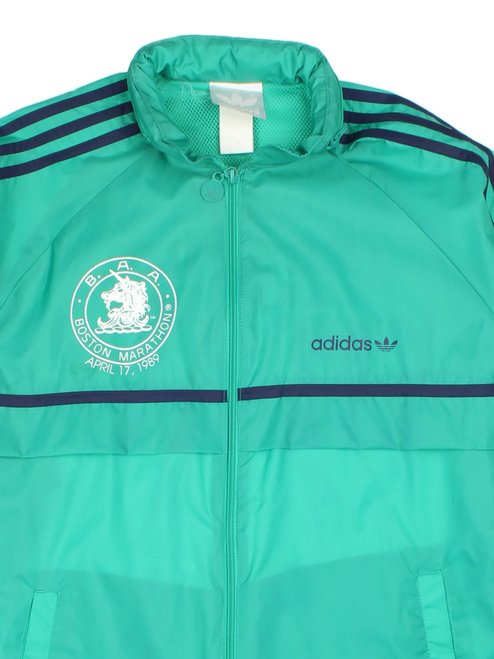1989 Adidas Boston Marathon Running Jacket in a green colourway. Zips up and has side pockets, and has the logos printed on the front and spell out on the back.