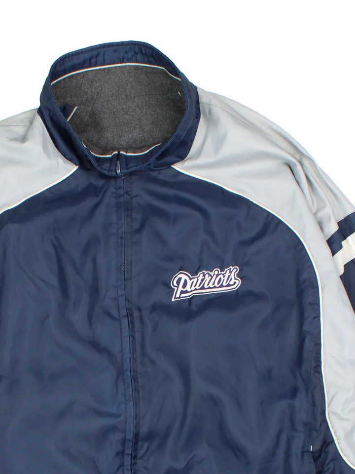 New England Patriots NFL Reversible Jacket in either a blue jacket colourway or grey fleece option. Zips up and has side pockets, and has the team logo embroidered on the front and back.
