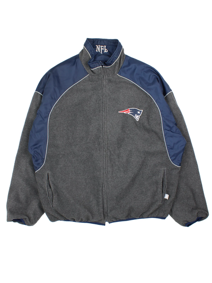 New England Patriots NFL Reversible Jacket in either a blue jacket colourway or grey fleece option. Zips up and has side pockets, and has the team logo embroidered on the front and back.