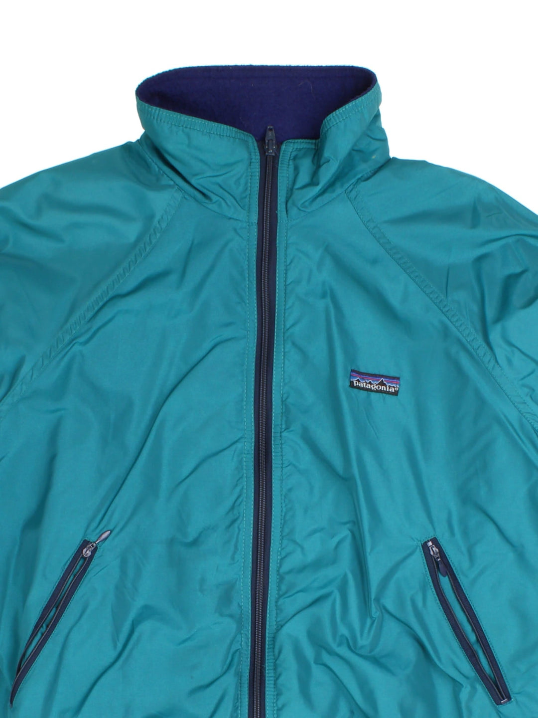 Patagonia Fleece Lined Bomber Jacket in a green colourway with navy cuffed sleeves and hem. Full zip with double front pockets and small classic logo.