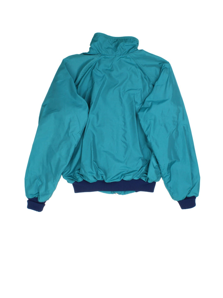 Patagonia Fleece Lined Bomber Jacket in a green colourway with navy cuffed sleeves and hem. Full zip with double front pockets and small classic logo.