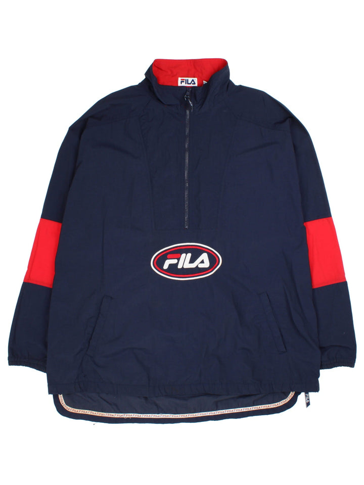 Fila 90's Windbreaker Jacket in a blue colourway with red panelling on the sleeves. Half zip with two pockets on the front and large classic logo with also a zip on the hem.