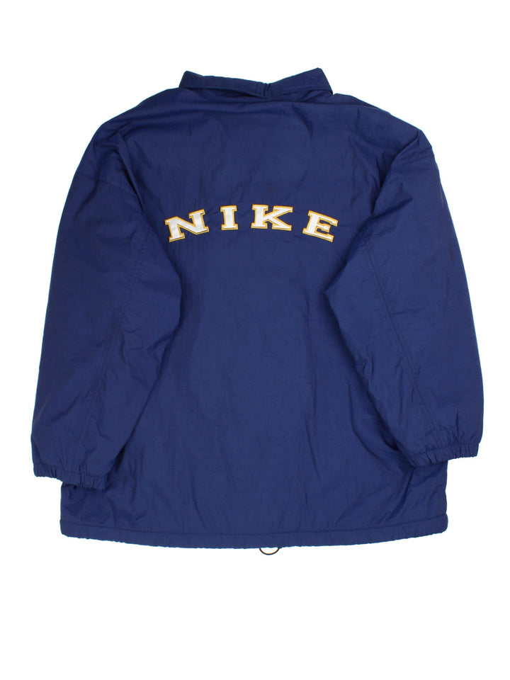 Nike Coach Jacket in a blue colourway. Fleece lining with full button up front, double zip pocket with small classic nike swoosh. Large Nike logo across the back.