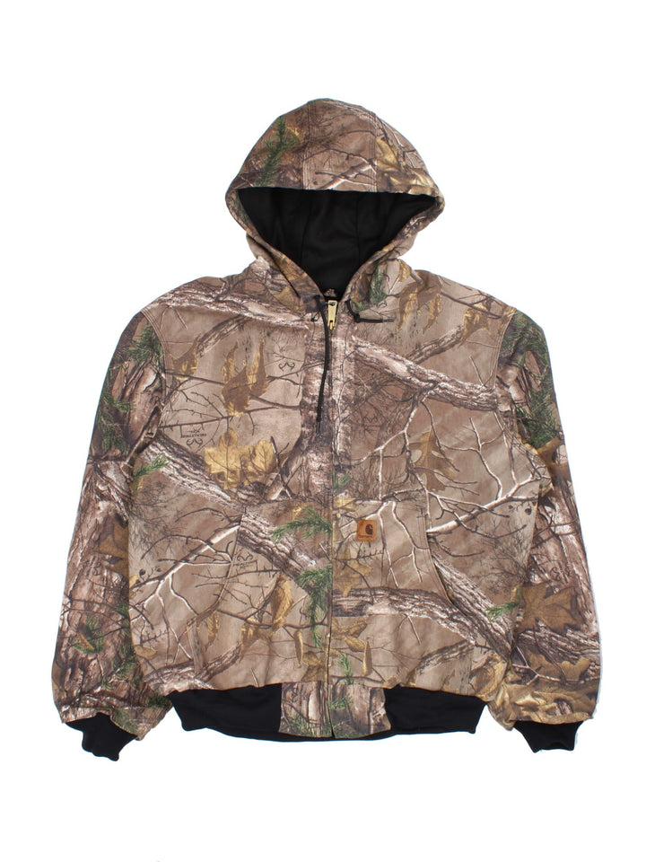Carhartt Real Tree Camo Active Jacket in a brown and green colourway. Zips up and has side pockets, hooded, and has the logo embroidered on the front.