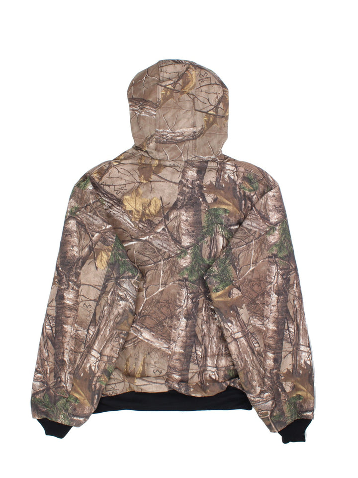 Carhartt Real Tree Camo Active Jacket in a brown and green colourway. Zips up and has side pockets, hooded, and has the logo embroidered on the front.