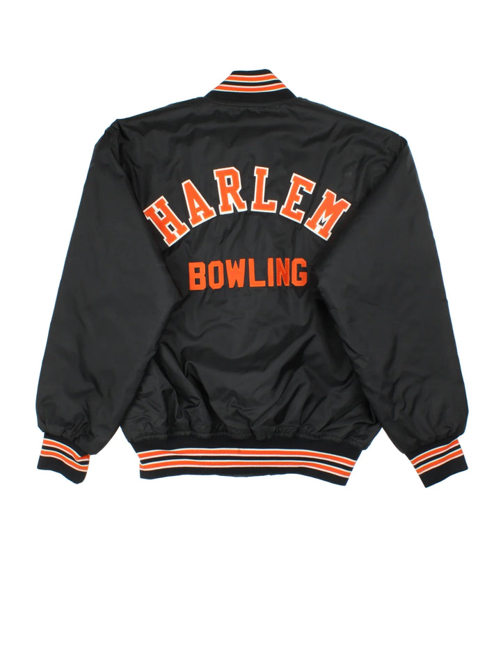 Vintage Harlem Bowling Team Varsity Jacket in a black colourway with orange detailing. Full button up front, multiple pockets and small logo on the front. Large team logo across the back.