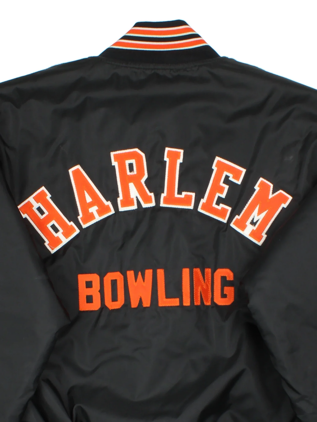 Vintage Harlem Bowling Team Varsity Jacket in a black colourway with orange detailing. Full button up front, multiple pockets and small logo on the front. Large team logo across the back.