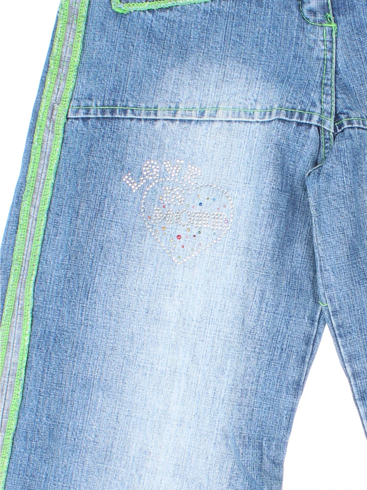 Y2K Love Is More Jeans in blue colourway with multiple pockets, contrast stitching and diamante detailing on the front.