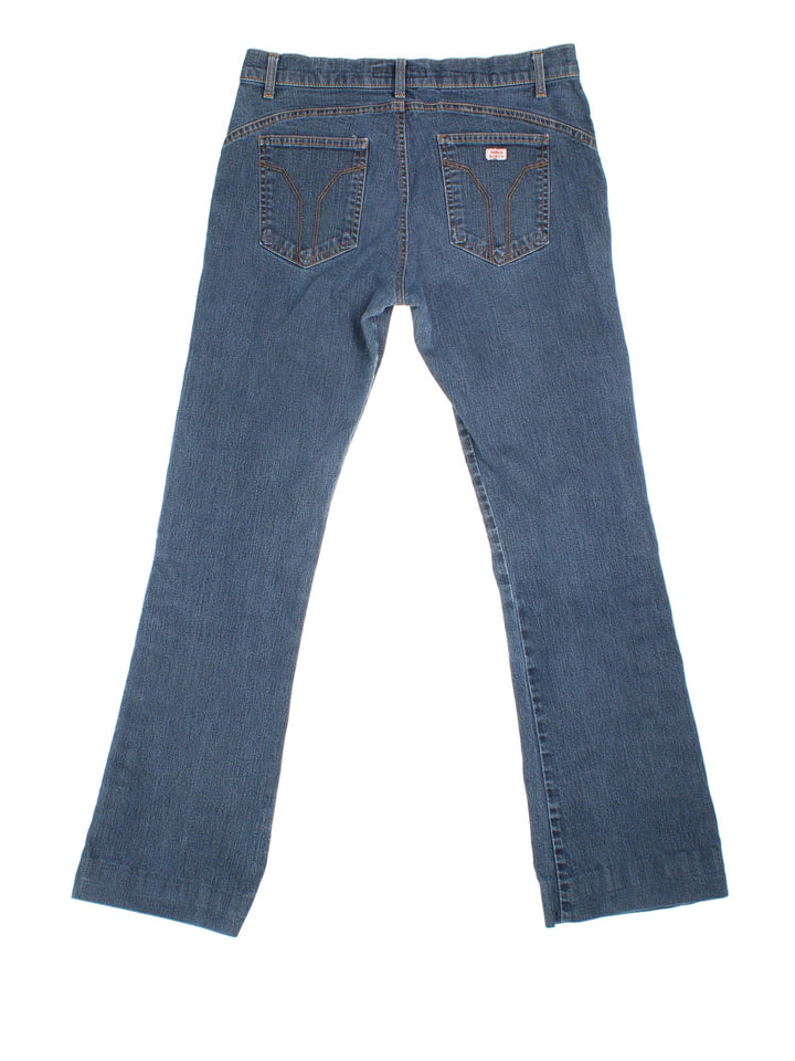 Y2K Miss Sixty Flared Popper Jeans in blue colourway with multiple pockets, popper buttons on the side of the legs, and the logo embroidered on the back.