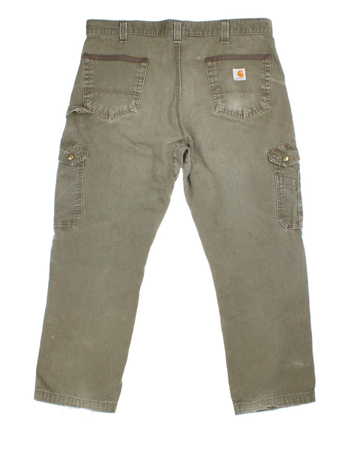 Carhartt Cargo Trousers in a green colourway with multiple pockets and the logo embroidered on the back.