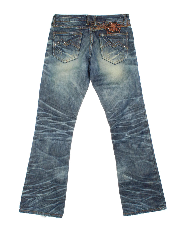Y2K Diamante Flared Jeans in blue colourway, with multiple pockets, contrast stitching and diamante detailing on the front/back.