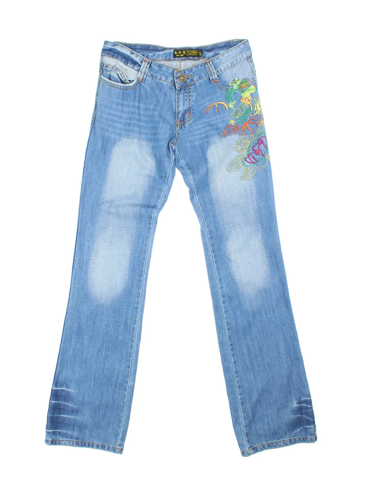 Y2K Embroidered Flared Jeans in blue colourway with multiple pockets, contrast stitching and floral detailing on the front.